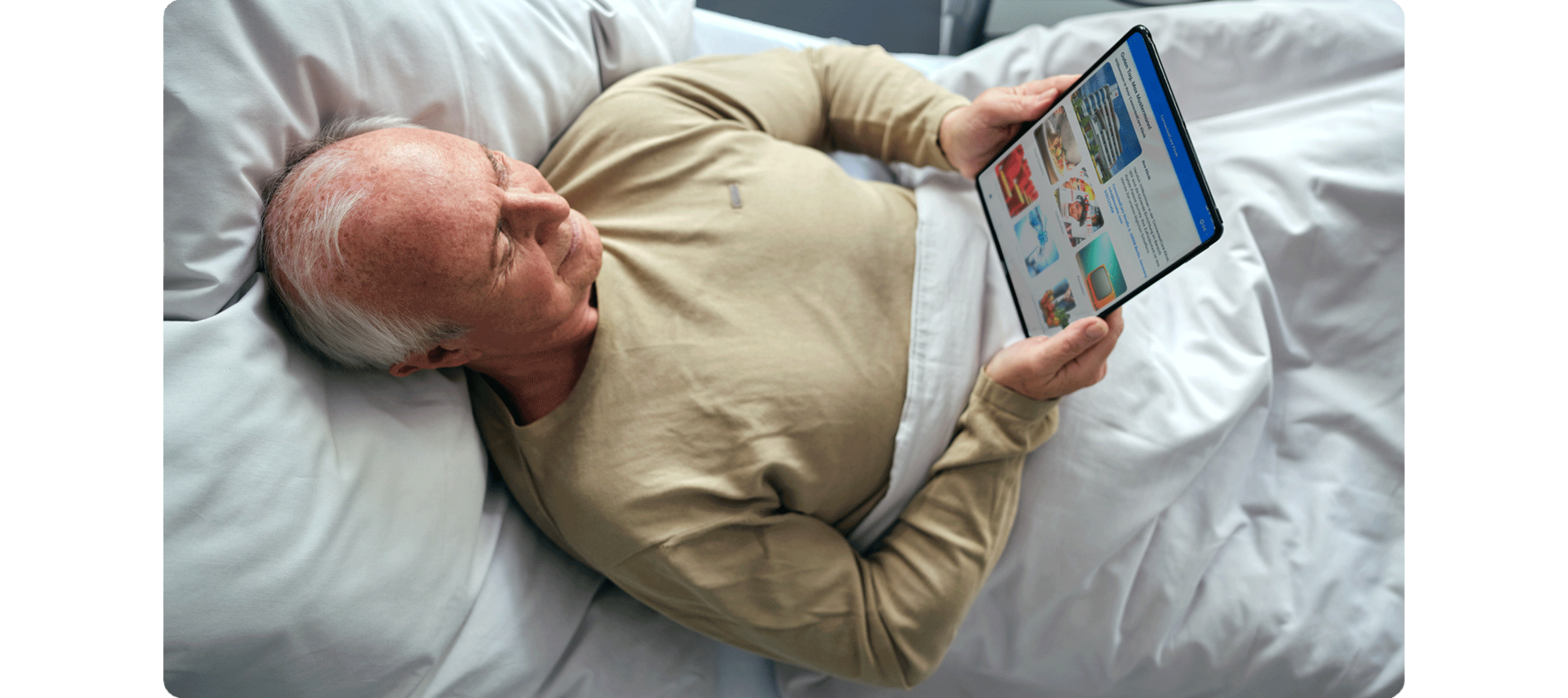 BEWATEC Patientenentertainment | Patient liegt im Bett und liest auf dem iPad, Bild von oben