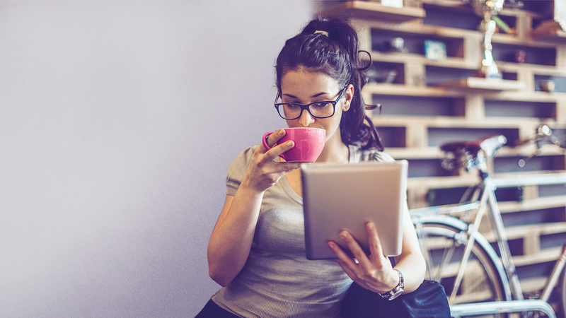 BEWATEC Partner, Skoobe, junge Frau trinkt Kaffee und liest eBook auf Tablet